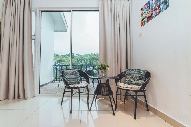 Uma varanda com duas cadeiras, uma mesa, porta de vidro deslizante e um quadro na parede.