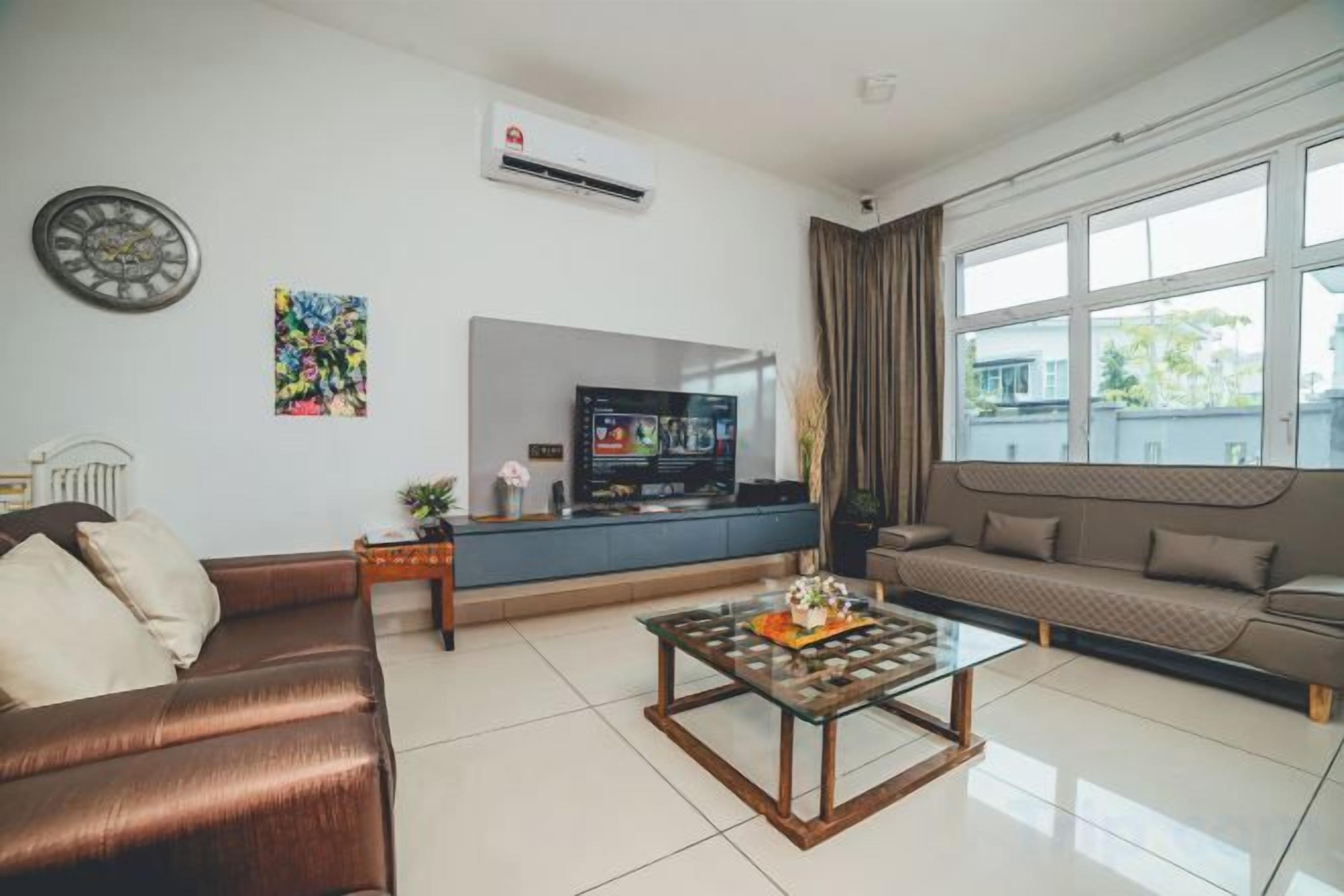Uma sala de estar moderna com sofá, mesa de centro, televisão e janela com cortinas.