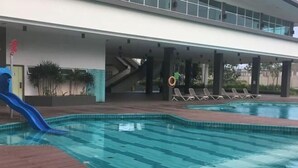 A swimming pool with a blue slide, lounge chairs, and a covered area with stairs. - d'Lux 6BR16-25px Pool/BBQ/NetFlx/HotPot/KTV/Mahjong (Bandar Penawar)