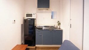 A compact kitchen with a refrigerator, microwave, and sink.
