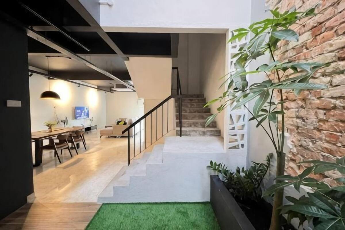 Un interior moderno con una escalera, un comedor y una sala de estar.