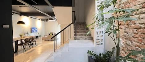 A modern interior with a staircase, a dining area, and a living space.