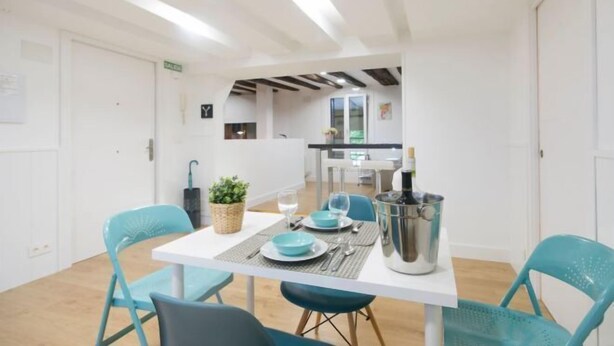 A modern dining area with a white table, teal chairs, and a metal bucket. - OLD TOWN NEAR THE BEACH by www.sansebastianapartments.es (San Sebastian)