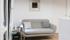 A modern living room with a grey sofa, two patterned cushions, a small table with a lamp, and a framed picture on the wall. - OLD TOWN NEAR THE BEACH by www.sansebastianapartments.es (San Sebastian)