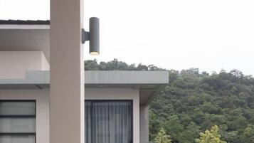 A modern building with a flat roof, a visible window, and a light fixture.
