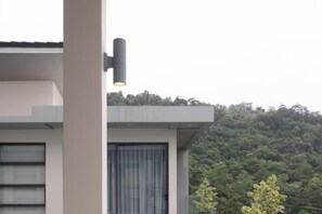 Un edificio moderno con techo plano, ventana a la vista y una lámpara.