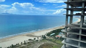 A high-rise building with a view of a beach and ocean. - Luxury Ocean View Suites_My Khe Beach_Hinata Apartment (Da Nang)