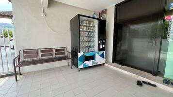 A vending machine, a bench, and a closed door.