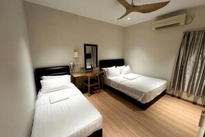 Ein Hotelzimmer mit zwei Betten, einem Schreibtisch, einem Stuhl, einem Deckenventilator und einer Klimaanlage.