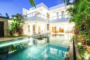 A modern two-story house with a swimming pool, outdoor seating, and lush landscaping. - VIlla SEVERINNE (Bali)