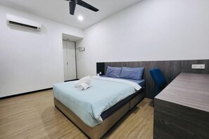 Ein modernes Schlafzimmer mit einem Bett, einem Schreibtisch, einem Deckenventilator und einer Tür.