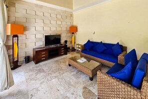 Ein Wohnzimmer mit Fernseher, Sofa und Couchtisch.