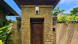 A stone building with a wooden door, a small window, and a sign above the door. - The Lavana Villa Bukit Jimbaran (2 Bedroom Villa with Private Pool - Minimum Stay 3 Nights) (Bali)