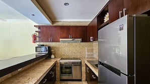 A modern kitchen with dark wooden cabinets, a stainless steel refrigerator, a built-in oven, and a microwave. - The Lavana Villa Bukit Jimbaran (2 Bedroom Villa with Private Pool - Minimum Stay 3 Nights) (Bali)