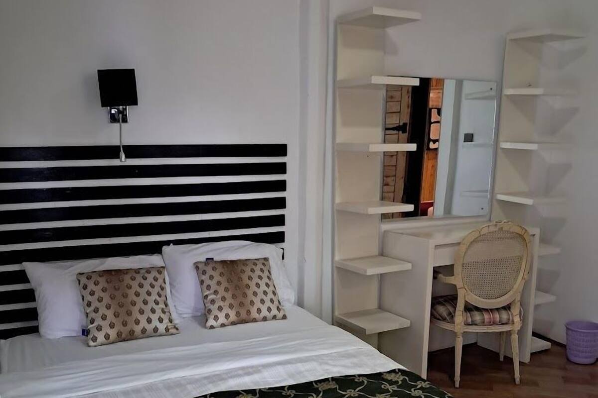 Une chambre bien rangée, avec un lit, un bureau et une chaise.