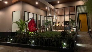 A modern house with large glass windows, a wooden deck, and a yellow door. - OYO 1177 The Great Molave (Alfonso)