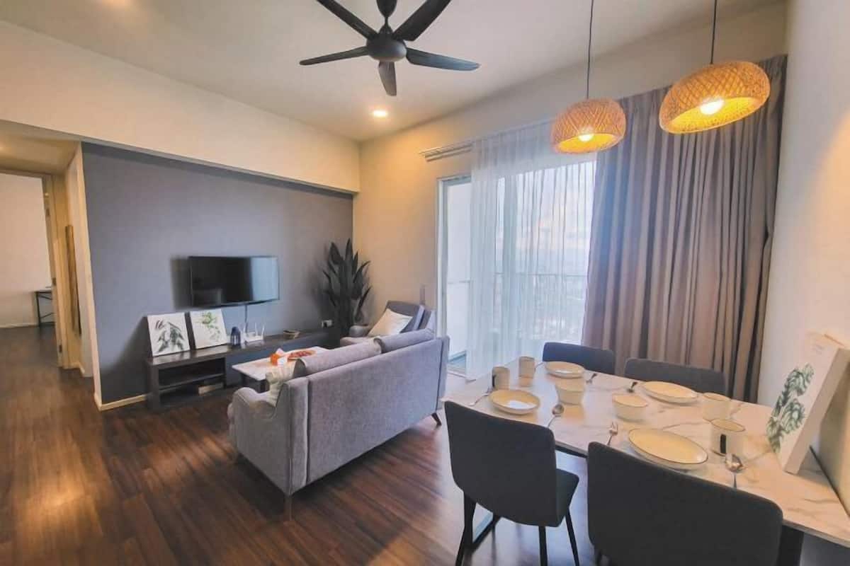 A modern living room with a sofa, dining table, and ceiling fan.