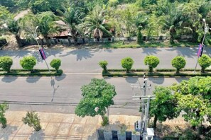 A road with a median strip, trees, and a flag.