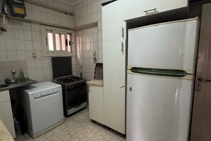 Une cuisine compacte équipée d’un lave-vaisselle, d’une cuisinière, d’un four et d’un réfrigérateur.