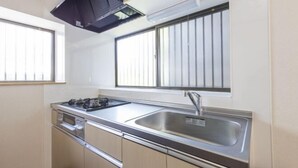 A compact kitchen with a gas stove, sink, and built-in oven. - Ikebukuro 15min｜Family House｜8Guests (Tokyo)