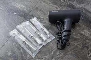 A black hairdryer and three clear plastic packets on a marble floor. - Ikebukuro 15min｜Family House｜8Guests (Tokyo)