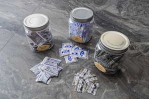 Three glass jars with lids on a marble floor, each containing rolled-up currency notes. - Ikebukuro 15min｜Family House｜8Guests (Tokyo)