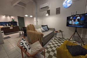 A modern living room with a sofa, a television, and a checkered floor. - W. House for group, Cozy Loft near Suvarnabhumi Airport (Bangkok)