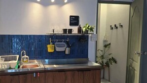 A modern kitchen with a blue backsplash, stainless steel appliances, and a dramatic exit sign. - W. House for group, Cozy Loft near Suvarnabhumi Airport (Bangkok)