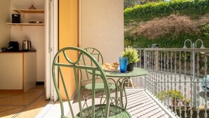 Ein Balkon mit Tisch, Stühlen und einer Topfpflanze.