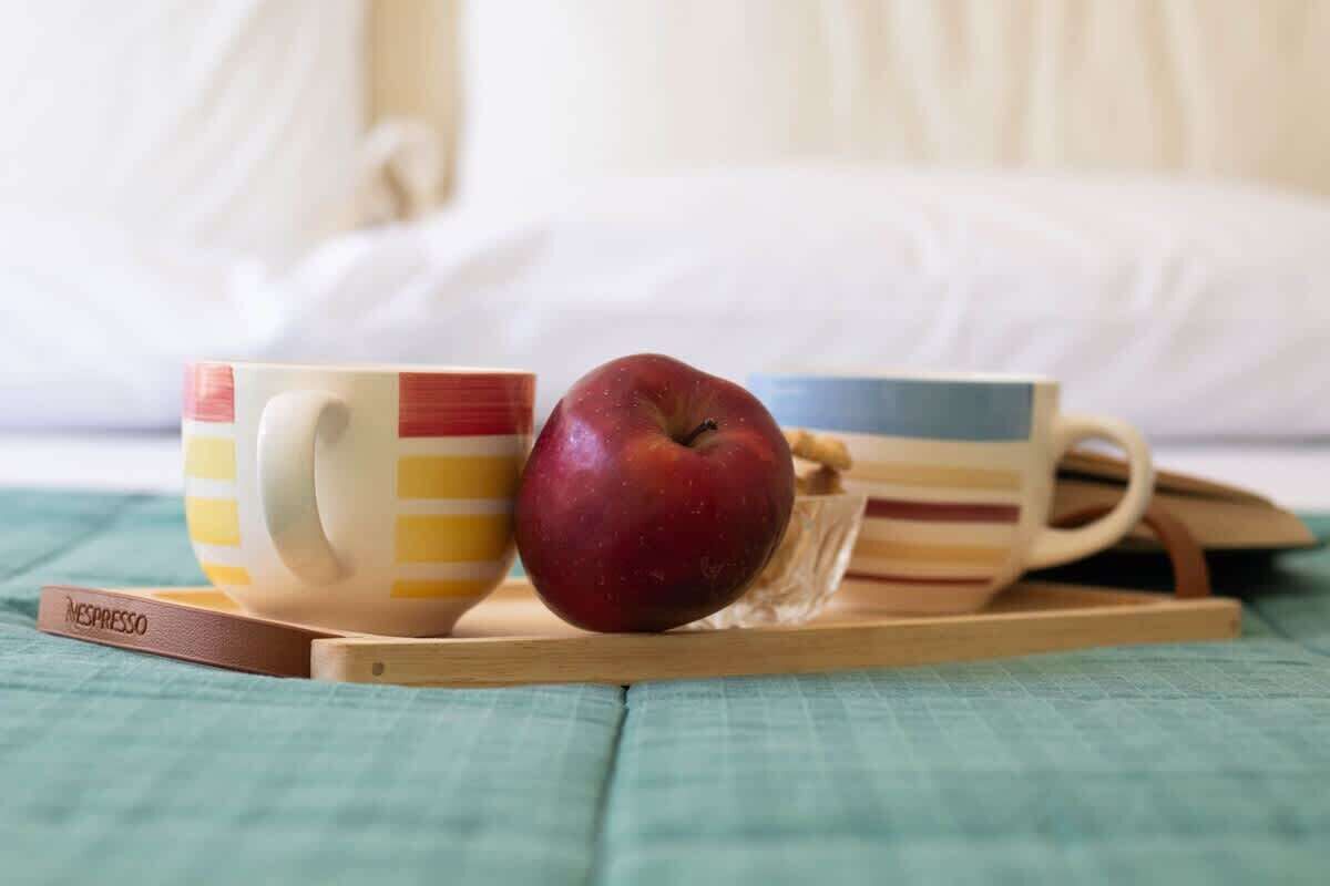 A bed with a white pillow and a teal bedspread.