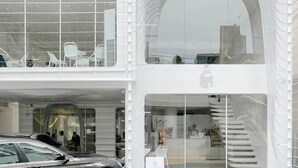 A modern building with a glass facade, a staircase, and a car parked outside. - T-House BKK 2floors near BTS with Swimming pool and Free Wifi (Bangkok)