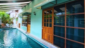 A swimming pool with a wooden door and a sign that reads "MADCAT BANKOK". - T-House BKK 2floors near BTS with Swimming pool and Free Wifi (Bangkok)