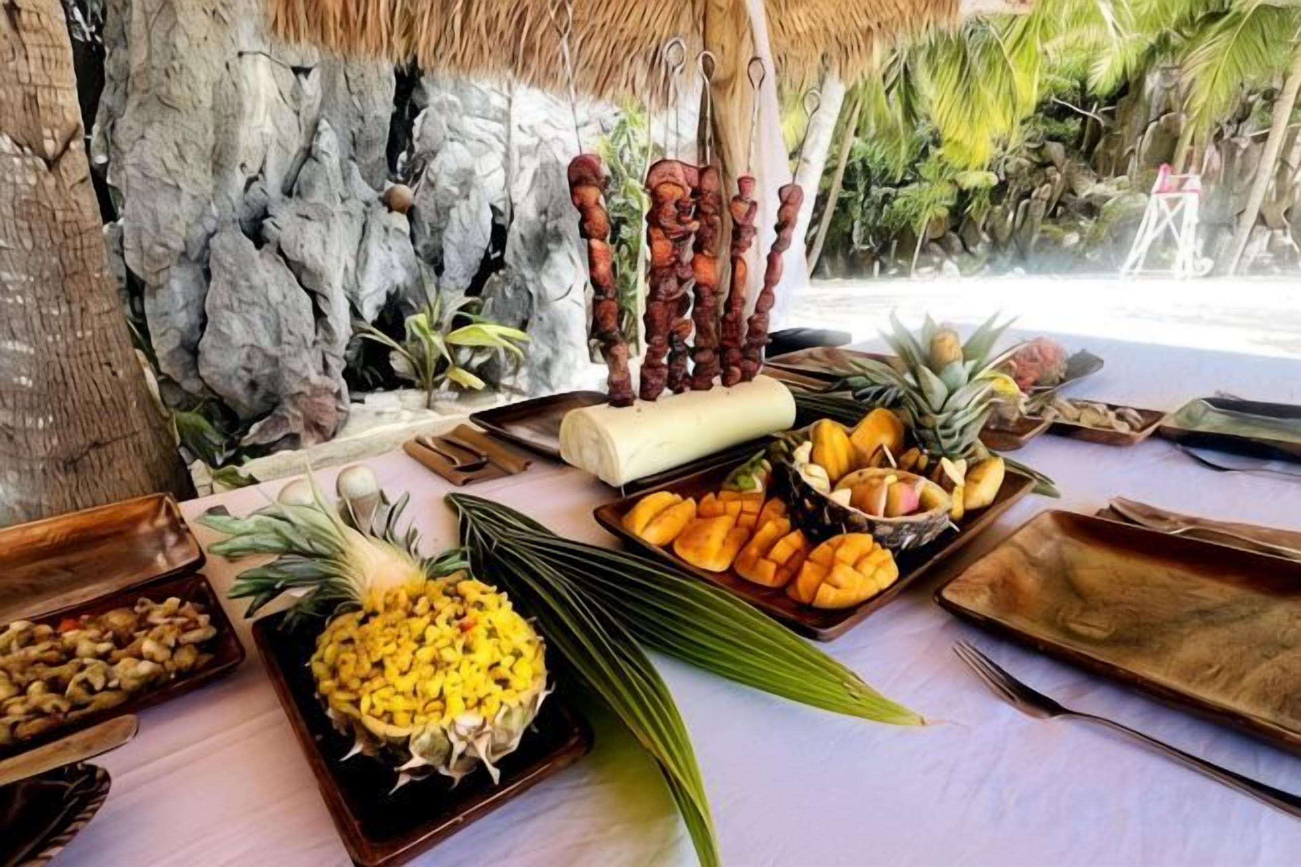 A table with various food items and a thatched roof structure.