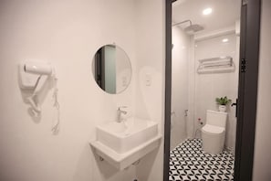 A bathroom with a white sink, mirror, hair dryer, and toilet. - Phu Gia Hotel 228 Le Van Luong (Ho Chi Minh City)