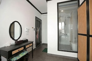 Ein Badezimmer mit Spiegel, Waschtisch, Dusche und einer Glastür zur Duschkabine.