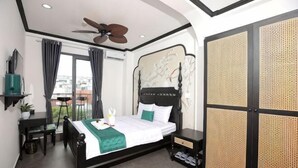 A bedroom with a bed, a ceiling fan, a desk, a chair, a TV, and a view of the city. - Phu Gia Hotel 228 Le Van Luong (Ho Chi Minh City)