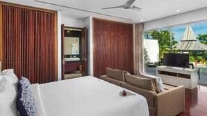 A modern hotel room with a large bed, a sofa, a TV, and a view of the outdoors. - Laemsingh Villa 3 (Phuket)