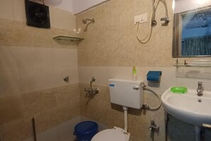 A bathroom with a toilet, sink, shower, and a window. - Parsik Hill Palace III (Thane)