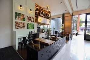 A modern restaurant interior with a counter, seating area, and large windows. - Luxury Apartment in Down Town (Chiang Mai)