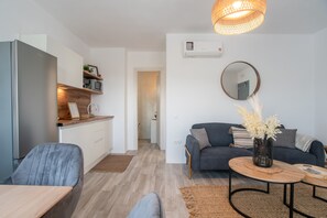 Ein moderner Wohnraum mit Küche, Essbereich und einer Couch mit Couchtisch.