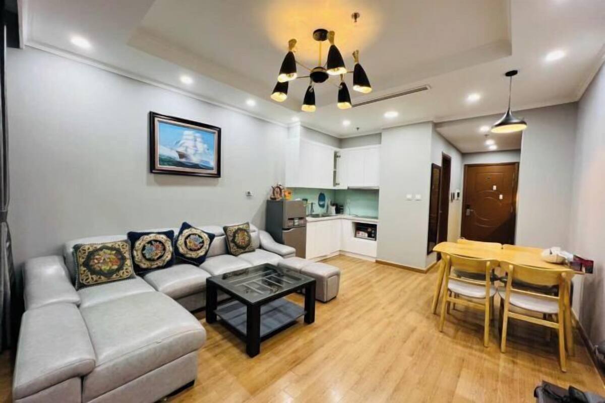 A modern living room with a sofa, coffee table, and dining table.