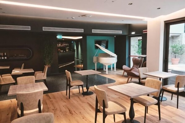 A modern interior with seating, a piano, and a bar area. - Hotel Al Caminetto Worldhotels Crafted (Torri del Benaco)