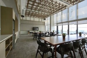 Ein geräumiges Büro mit einem großen Holztisch, schwarzen Stühlen und einem modernen Deckenstil.