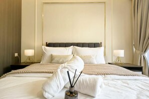 Ein Hotelzimmer mit einem großen Bett, zwei Nachttischen mit Lampen und einem Kopfteil.