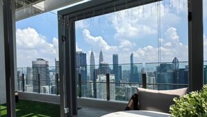 A modern room with a large window offering a city skyline view. - TRX AGILE Bukit Bintang Superior 8 Pax Family Suites (Kuala Lumpur)
