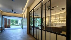 A modern interior with a kitchen area, wooden flooring, and ceiling fans. - TRX AGILE Bukit Bintang Superior 8 Pax Family Suites (Kuala Lumpur)