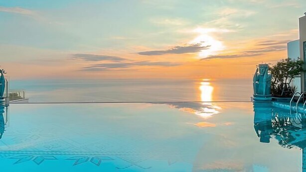 Une vue dégagée sur une piscine, avec un coucher de soleil en arrière-plan.