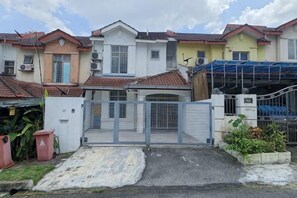 A residential building with a gated entrance, a covered carport, and a small garden area. - Damansara Damai 9Pax 4 Rooms (Petaling Jaya)