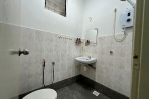 Ein Badezimmer mit Toilette, Waschbecken, Spiegel und Handtuchhalter.