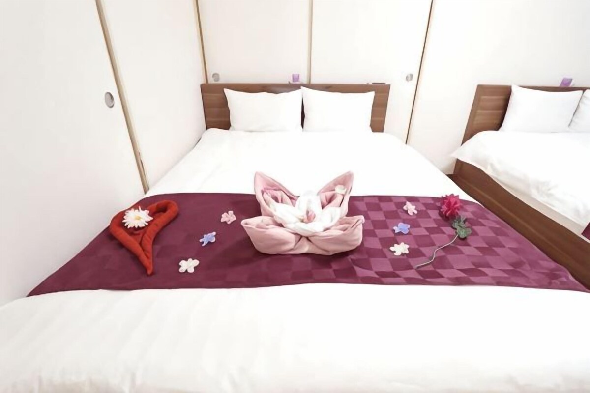 A hotel room with a large bed, a wooden headboard, and a checkered blanket.